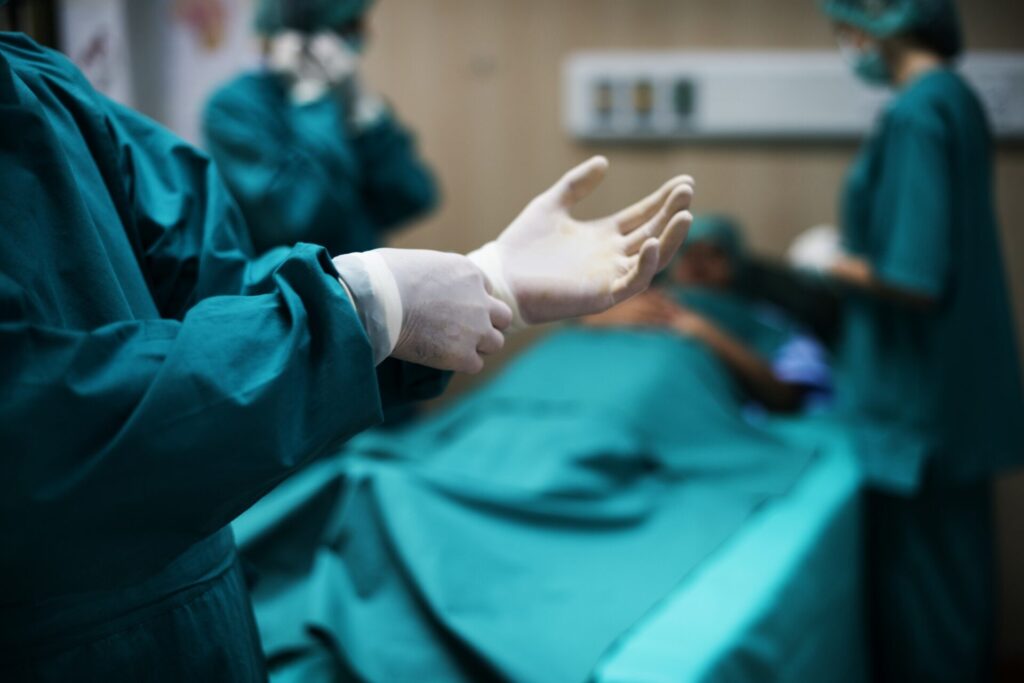 colon cancer screening christchurch specialist Surgeon putting on sterile gloves before performing surgery.